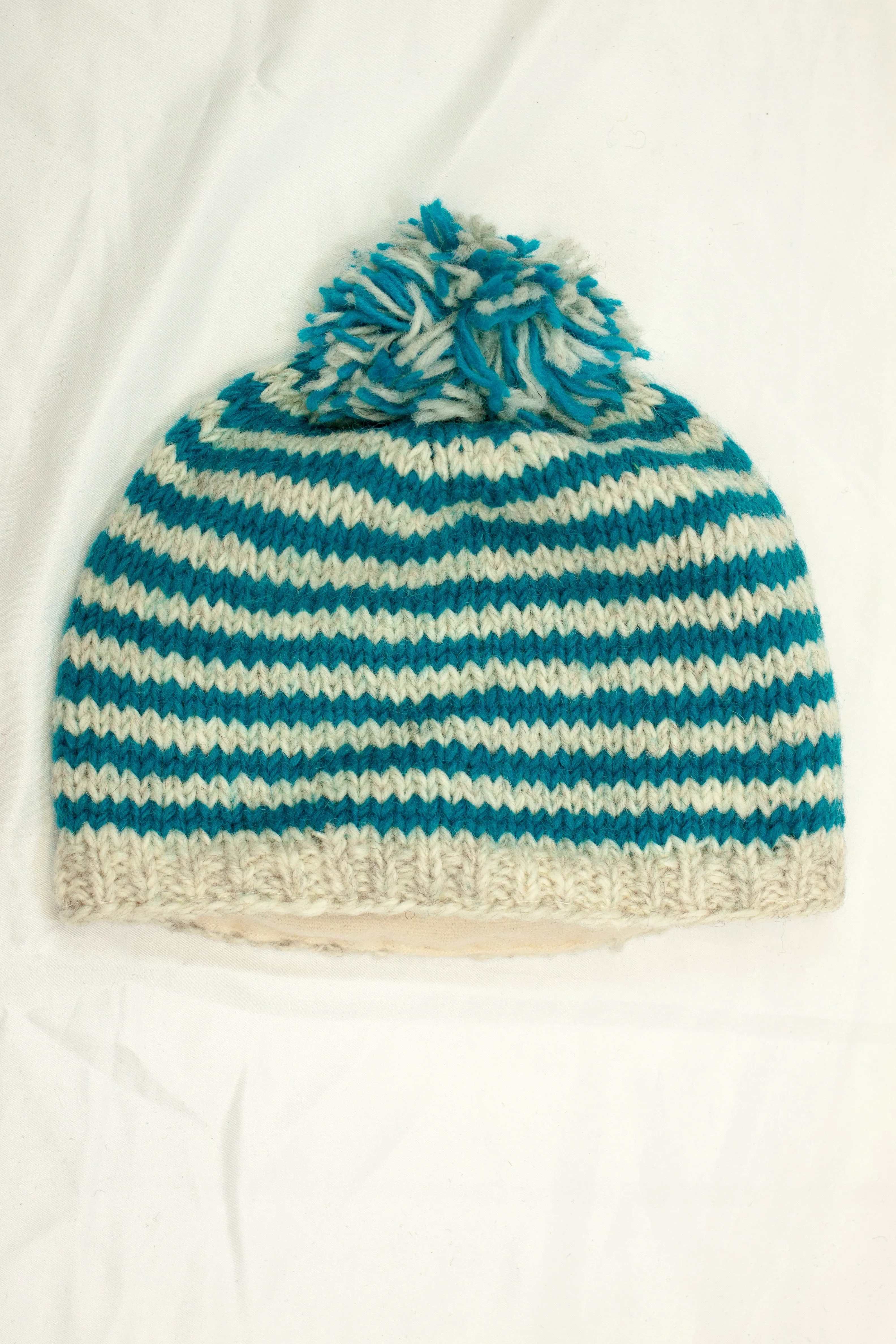 Hand knitted woolen pom pom beanie with soft fleece liner - unisex